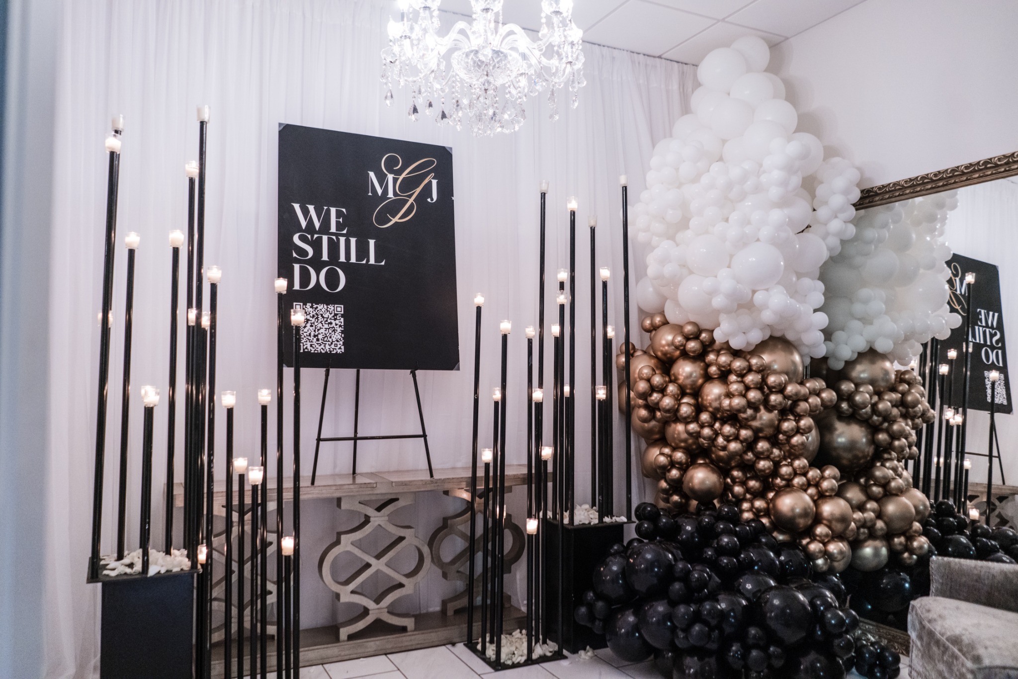 A personalized welcome display with black, white and bronze balloons and tall candle stands